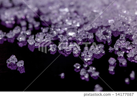White sugar crystals on a dark violet background 54177087