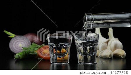 Pour alcohol drink vodka from bottle in shot Pour alcohol drink vodka from bottle in shot 54177728