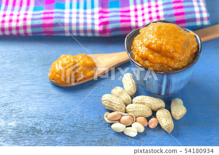 Bowl of peanut butter and spoon of peanut butter 54180934