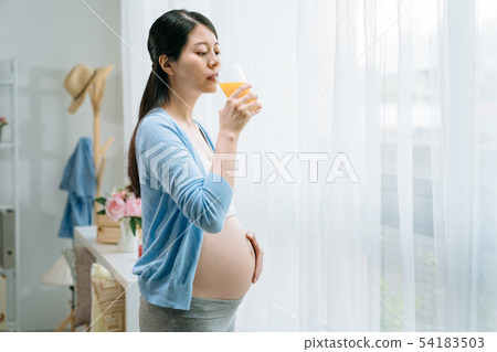 pregnant woman drinking juice smoothie at home 54183503