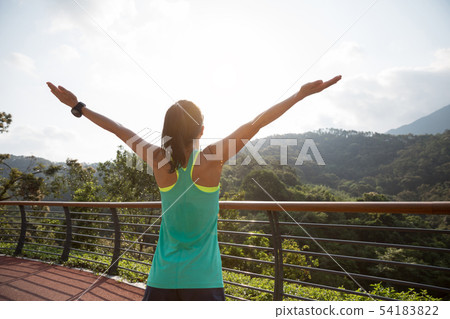 Woman runner outstretched arms on spring morning 54183822