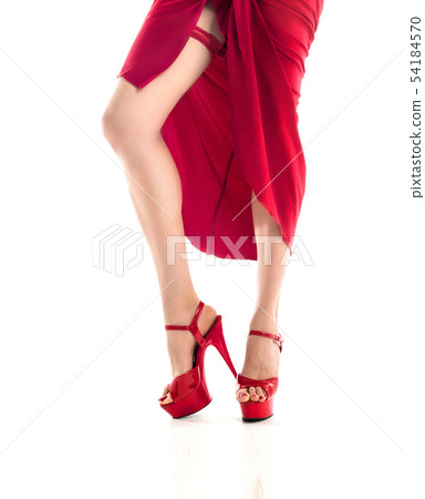 A red lace Garter on the leg, A pale skinned slim sexy woman in a luxury red dress showing her silky A red lace Garter on the leg, A pale skinned slim sexy woman in a luxury red dress showing her silky 54184570