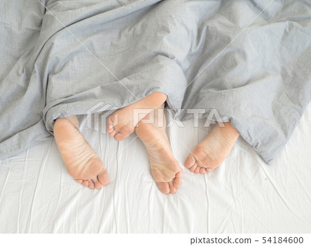 Feet of couple side by side in bed Feet of couple side by side in bed 54184600