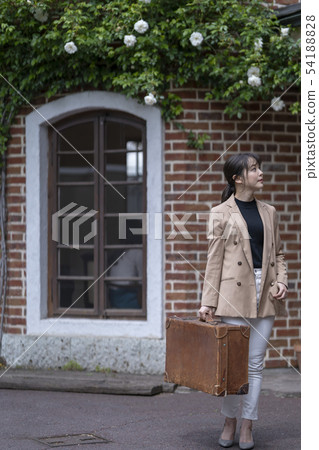 一個美麗的女人喜歡獨自旅行,同時看著西方磚建築與最喜歡的古董樹乾皮革 一個美麗的女人喜歡獨自旅行,同時看著西方磚建築與最喜歡的古董樹乾皮革 54188828