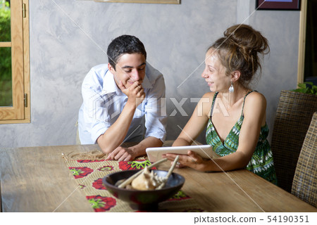 a young couple smiled looking at a digital tablet 54190351