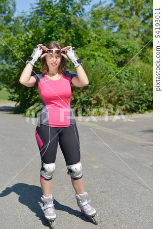 pretty young woman doing rollerskate on a track pretty young woman doing rollerskate on a track 54193011