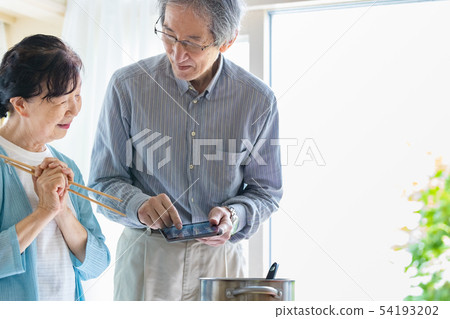 Senior couple tablet device kitchen Senior couple tablet device kitchen 54193202