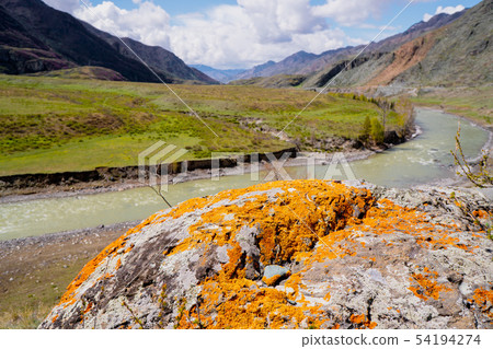 unusual stone formations with colored patches of lichen and moss on the background of mountains and 54194274
