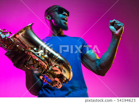 Young african-american jazz musician playing the saxophone Young african-american jazz musician playing the saxophone 54194623