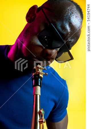 Young african-american jazz musician playing the saxophone Young african-american jazz musician playing the saxophone 54194744