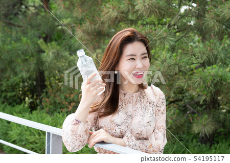 拿著被裝瓶的水的微笑的婦女 54195117