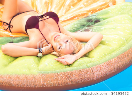 Beautiful young woman swims in the pool on 54195452