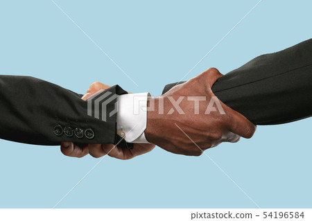 Two male hands shaking isolated on blue studio background Two male hands shaking isolated on blue studio background 54196584