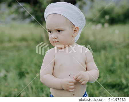 baby boy summer day in a meadow with green grass 54197283