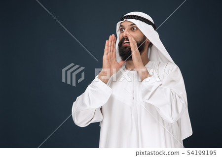 Arabian saudi man on dark blue studio background Arabian saudi man on dark blue studio background 54199195