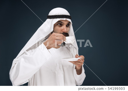 Arabian saudi man on dark blue studio background Arabian saudi man on dark blue studio background 54199303