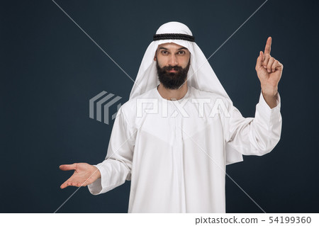 Arabian saudi man on dark blue studio background Arabian saudi man on dark blue studio background 54199360