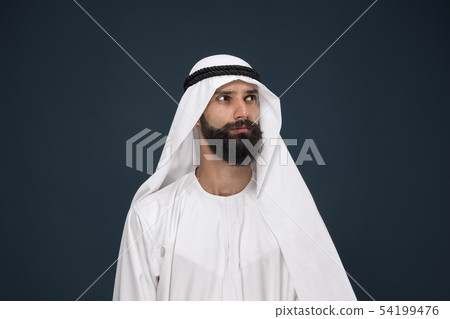 Arabian saudi businessman on dark blue studio background Arabian saudi businessman on dark blue studio background 54199476