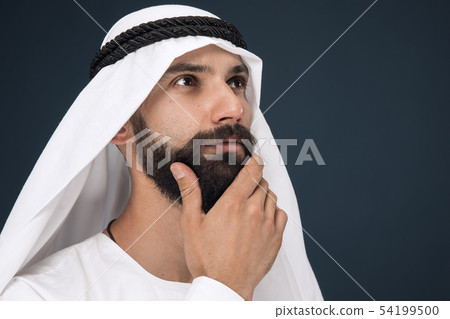 Arabian saudi businessman on dark blue studio background Arabian saudi businessman on dark blue studio background 54199500