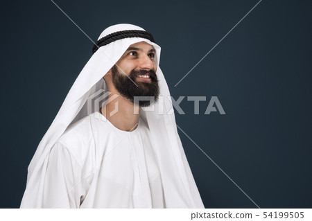 Arabian saudi businessman on dark blue studio background Arabian saudi businessman on dark blue studio background 54199505