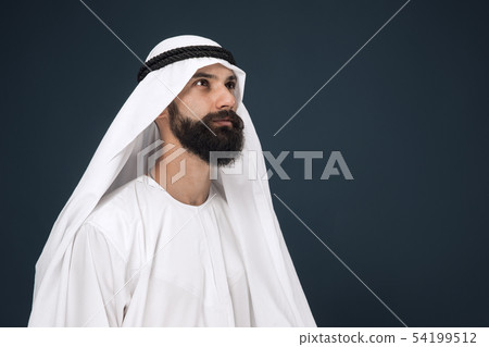 Arabian saudi businessman on dark blue studio background Arabian saudi businessman on dark blue studio background 54199512