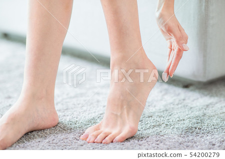 woman apply lotion with foot 54200279