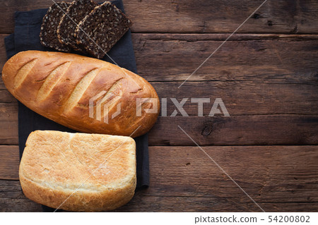 Different fresh bread, on old wooden table. Different fresh bread, on old wooden table. 54200802