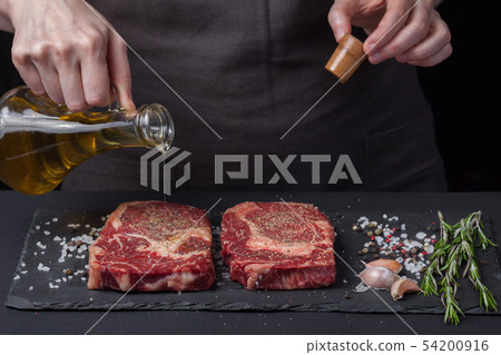The woman chef is preparing a beef steak. 54200916