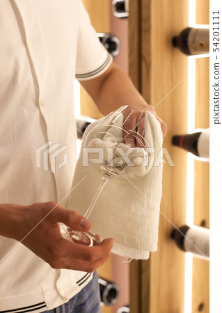 The bartender wipes his glass. The bartender wipes his glass. 54201111