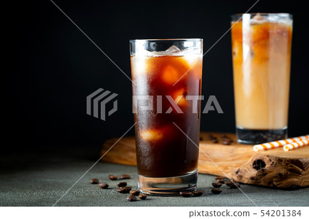 Ice coffee in a tall glass with cream poured over. Ice coffee in a tall glass with cream poured over. 54201384