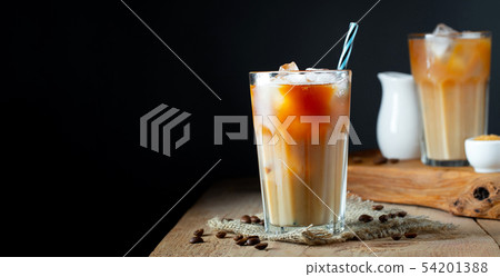 Ice coffee in a tall glass with cream poured over. 54201388