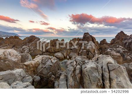 Cefalu. A picturesque sunrise over the sea and the breakwater. Cefalu. A picturesque sunrise over the sea and the breakwater. 54202996