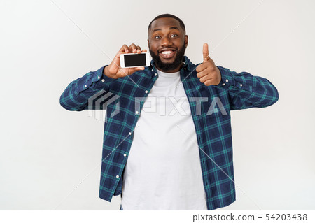 Handsome african american man isolated on grey background, presenting smart phone. 54203438