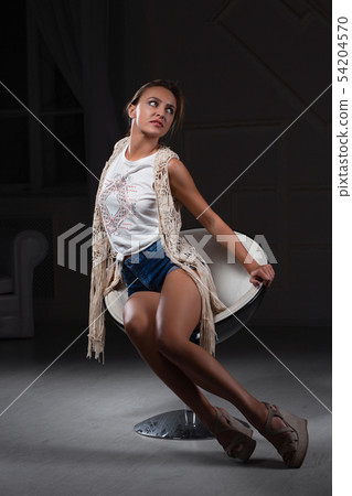 Perfect lady posing sitting on a chair. 54204570