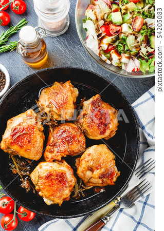Delicious fried chicken thighs in a cast iron 54205083