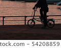 Sunset at the harbor, silhouette of the bike. 54208859