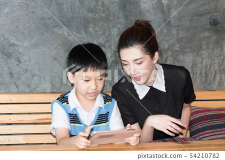 Asian,Woman and little boy sitting, playing tablet 54210782