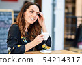 Middle-aged woman using tablet on coffee break in 54214317