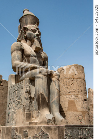 Egypt Luxor Temple. granite Statue of Ramesses II seated in front of columns 54215029