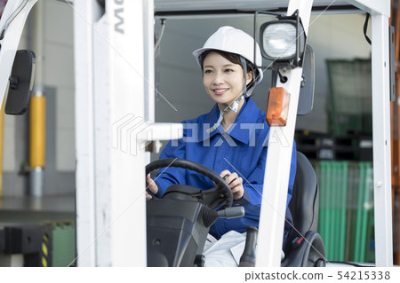 Female worker operating a forklift Female worker operating a forklift 54215338