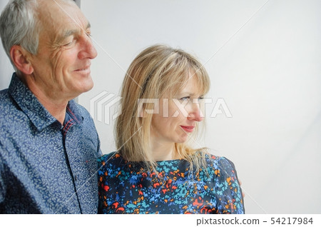 Portrait of Couple with Age Difference Standing near Opened Window inside the House. Elderly Man is 54217984