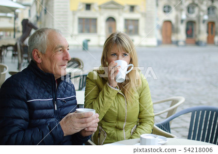 Portrait of happy romantic couple with age difference drinking coffee in cafe with terrace outdoors Portrait of happy romantic couple with age difference drinking coffee in cafe with terrace outdoors 54218006