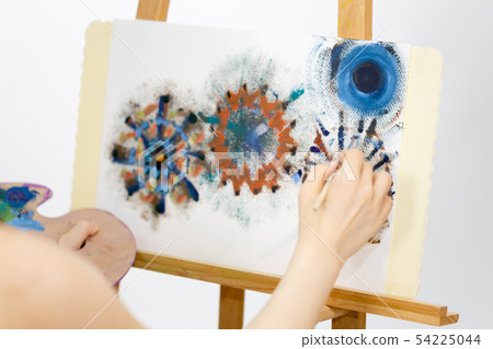 Artist painting on an easel Artist painting on an easel 54225044