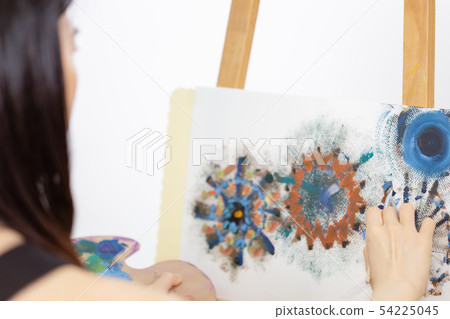 Artist painting on an easel Artist painting on an easel 54225045