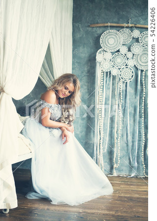 Cheerful blonde woman in light blue evening gown 54226406