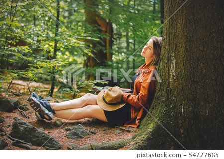 Style girl with backpack sitting in a stone in a summer time Style girl with backpack sitting in a stone in a summer time 54227685