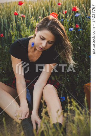 Young woman sitting on a roadside of countryside Young woman sitting on a roadside of countryside 54227767