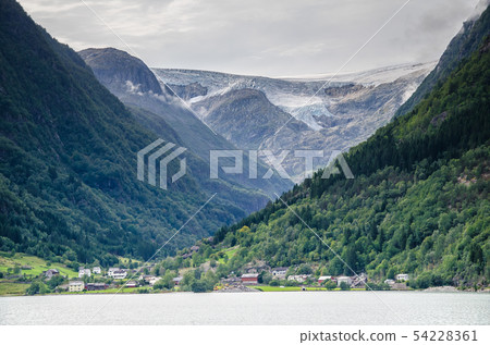 DIstant view of a Buarbreen glacier valley with a small village in front in Odda region, Norway DIstant view of a Buarbreen glacier valley with a small village in front in Odda region, Norway 54228361