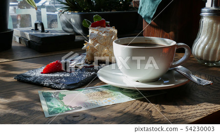 Kuwaiti banknotes lying under a cup of coffee Kuwaiti banknotes lying under a cup of coffee 54230003