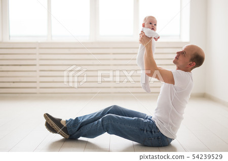 Children, family and fatherhood concept - happy bald father holding baby daughter in white room Children, family and fatherhood concept - happy bald father holding baby daughter in white room 54239529
